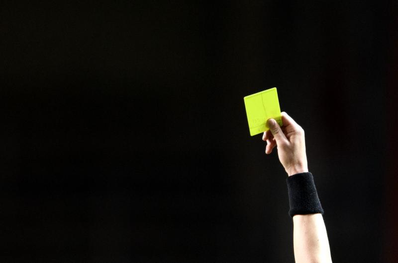 Domare visar gult kort.