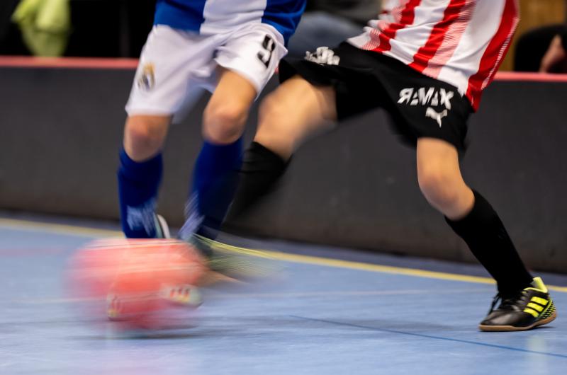 Fotboll rör sig snabbt och två spelare i duell. 